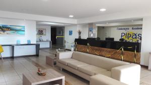 a lobby with a couch and a table in a room at Imo Apart Pipa's Ocean in Pipa