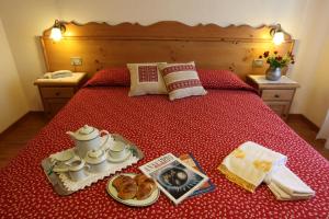 a bed with a bedspread and a book on it at Hotel Aiguille Noire in Courmayeur
