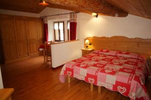 a bedroom with a bed with a red and white blanket at Hotel Aiguille Noire in Courmayeur