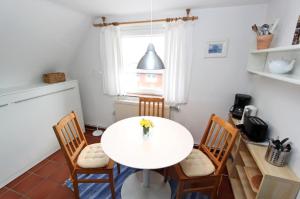 a white table and chairs in a kitchen with a window at Haus-Atlantis-Whg-2-Duenenblick in Hörnum