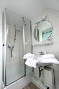 a bathroom with a shower and a sink and a mirror at Haus-Atlantis-Whg-2-Duenenblick in Hörnum