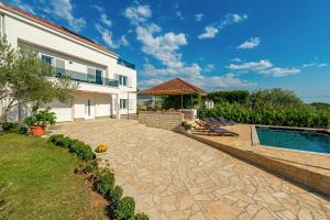 a backyard with a swimming pool and a house at Apartments Luka & Lorena in Galovac