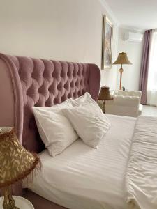 a bedroom with a bed with a large white pillow at Opera Center Hotel & Apartments in Lviv