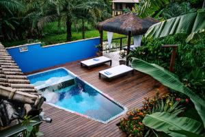 an outdoor deck with a swimming pool and a house at Barra Suítes in Barra Grande