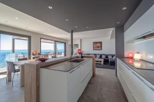 eine offene Küche und ein Wohnzimmer mit Blick auf das Meer in der Unterkunft Villa Velazquez Canyelles Almadrava - Immo Barneda in Roses