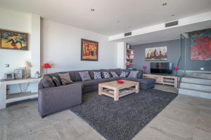 ein Wohnzimmer mit einem Sofa und einem Tisch in der Unterkunft Villa Velazquez Canyelles Almadrava - Immo Barneda in Roses