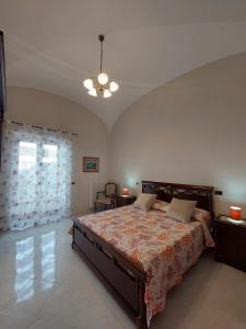 a bedroom with a bed and a chandelier at Dai nonni Seaview with roof terrace over the sea in Scala