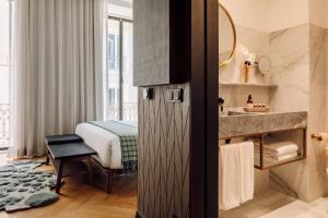 a hotel room with a bathroom with a bed and a sink at Hotel Hotel - Member of Design Hotels in Lisbon