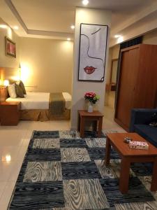um quarto de hotel com uma cama e um sofá em تاج الخليج للشقق المخدومة 2 em Turaif