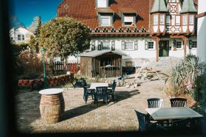 un patio con mesas y sillas frente a una casa en Astheimer Schlösschen, en Trebur