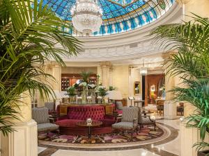 Hotel Fenix Gran Meliá - The Leading Hotels of the World في مدريد: لوبي فيه اريكه حمراء وسقف زجاجي
