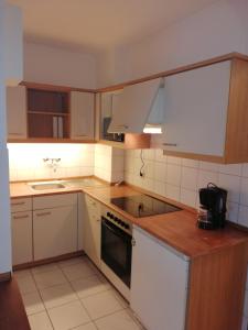 - une cuisine avec des appareils blancs et des armoires en bois dans l'établissement Apart-EG-01, à Darmstadt
