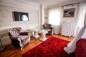sala de estar con 2 sillas y alfombra roja en Hotel BOB en Sarajevo