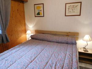 een slaapkamer met een bed met een blauwe sprei en 2 lampen bij Appartement Chamonix-Mont-Blanc, 2 pièces, 5 personnes - FR-1-517-39 in Chamonix-Mont-Blanc