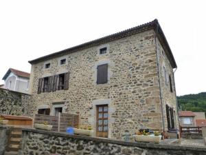 an old stone building with flowers in front of it at Gîte Chavaniac-Lafayette, 2 pièces, 2 personnes - FR-1-582-198 in Chavaniac-Lafayette