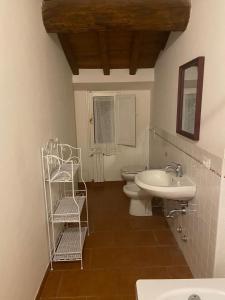 ein Badezimmer mit einem Waschbecken, einem WC und einem Spiegel in der Unterkunft Appartamento con cortile privato e splendida vista in Viterbo