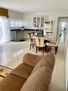 a living room with a couch and a table and chairs at Casa Boraceia in Boracéia