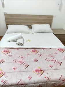 a large bed with pink roses on it at fanti homes in Rome