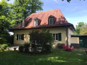una pequeña casa amarilla con techo rojo en Ferienwohnung Villa Tana Miesbach en Miesbach