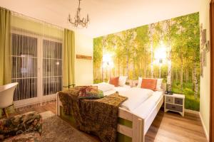 a bedroom with two beds and a wall with trees at Hotel Restaurant Grüner Baum und Altes Tor in Bad Waldsee