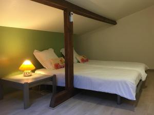ein Schlafzimmer mit 2 Betten und einem Tisch mit einer Lampe in der Unterkunft Gîte Toul, 2 pièces, 3 personnes - FR-1-584-60 in Toul