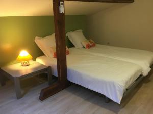 2 Betten in einem Zimmer mit einer Lampe auf einem Tisch in der Unterkunft Gîte Toul, 2 pièces, 3 personnes - FR-1-584-60 in Toul