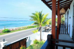 a house with a view of the ocean and a palm tree at Horizon Palace - Kabalana in Ahangama