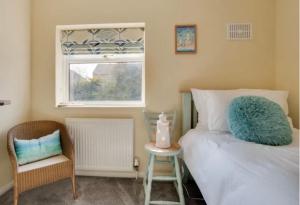 a bedroom with a bed and a chair and a window at Maggie May in Whitby