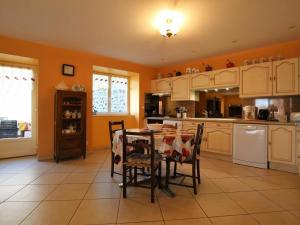 a kitchen with a table and chairs and orange walls at Gîte Rauret, 4 pièces, 7 personnes - FR-1-582-203 in Rauret