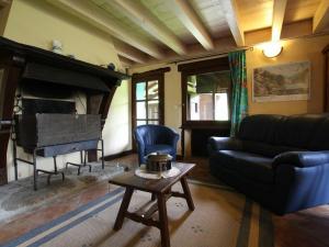 a living room with a couch and a piano at Gîte Villeneuve-d'Allier, 4 pièces, 6 personnes - FR-1-582-208 in Villeneuve-dʼAllier