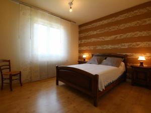 een slaapkamer met een bed en een houten muur bij Gîte Retournac, 3 pièces, 4 personnes - FR-1-582-248 in Retournac