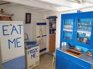 a kitchen with a blue cabinet and a fridge at Casa Ericeira in Ericeira