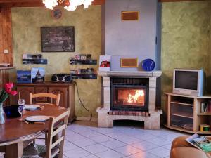 sala de estar con chimenea, mesa y TV en Gîte Les Estables, 3 pièces, 6 personnes - FR-1-582-148, en Les Estables