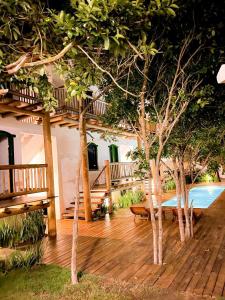 una terrazza in legno con panca e alcuni alberi di Pousada Villa dos Corais a Trancoso