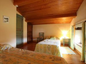 a bedroom with two beds and a wooden ceiling at Gîte familial avec grande terrasse à Auzat, proche baignades et sites historiques - FR-1-582-183 in Villeneuve-dʼAllier