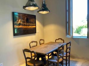 a dining room with a wooden table and chairs at Gîte élégant avec jardin privé, climatisation et parking à Ainay-le-Vieil - FR-1-586-7 in Ainay-le-Vieil +3 photos