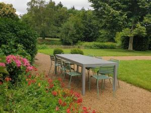 uma mesa e cadeiras num jardim com flores em Gîte Cossé-le-Vivien, 5 pièces, 8 personnes - FR-1-600-113 em Cossé-le-Vivien