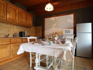 een keuken met een tafel en een witte koelkast bij Gîte Saint-Paulien, 4 pièces, 6 personnes - FR-1-582-266 in Saint-Paulien