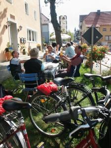a group of people sitting at a table with bikes at Gasthof zur Post in Vohenstrauß