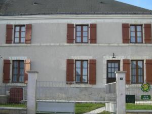 a white house with brown shuttered windows and a gate at Maison Authentique en Berry avec Jeux, Jardin, à 30 min du Zoo de Beauval - FR-1-591-119 in Gehée