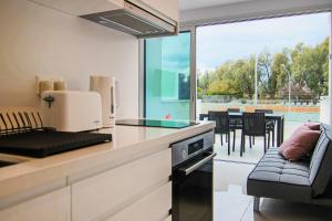 a kitchen with a counter with a couch and a window at Phaedrus Living - Seaside Luxury Flat Harbour 109 in Paphos