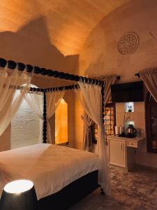 Midyat的住宿－Kasri Mezopotamya，一间卧室配有一张带天蓬的床