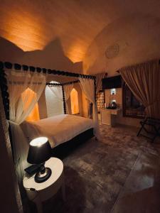 - une chambre avec un lit et une lampe sur une table dans l'établissement Kasri Mezopotamya, à Midyat