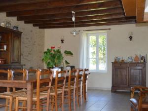 a dining room with a wooden table and chairs at Ancienne ferme rénovée au cœur de la Vallée Noire avec jardin clos, vélos et équipements complets - FR-1-591-111 in Tranzault