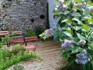dos bancos sentados en una terraza de madera en un jardín en Gîte Tonnoy, 3 pièces, 4 personnes - FR-1-584-35, en Tonnoy