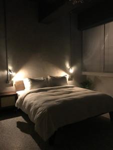 a bedroom with a large bed with lights on it at The Retro Tai-Pan in Tainan