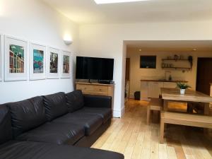 a living room with a black couch and a table at The Big Bristol House in Bristol