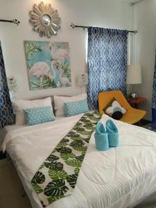 a bedroom with a bed with blue shoes on it at Cessna Park Resort and Hotel in Ban Hua Na