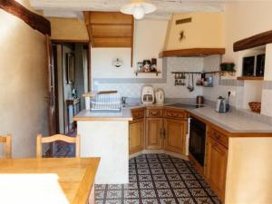 a kitchen with wooden cabinets and a counter top at Maison spacieuse avec jardin, terrasse et tout confort, calme assuré à Poinville - FR-1-581-16 in Poinville