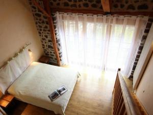 ein Schlafzimmer mit einem Bett und einem großen Fenster in der Unterkunft Gîte Saint-Christophe-sur-Dolaison, 4 pièces, 8 personnes - FR-1-582-284 in Saint-Christophe-sur-Dolaison